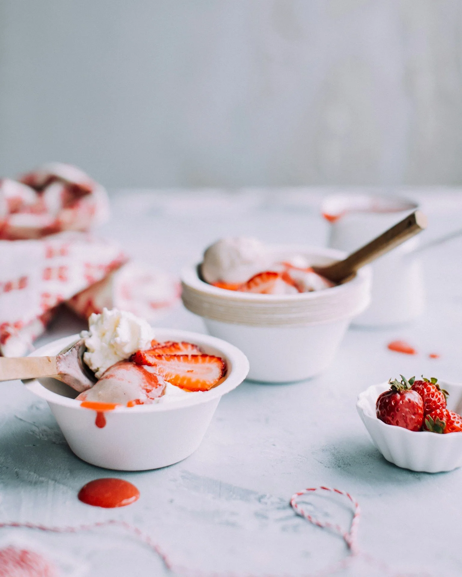 White bowls of strawberries and cream